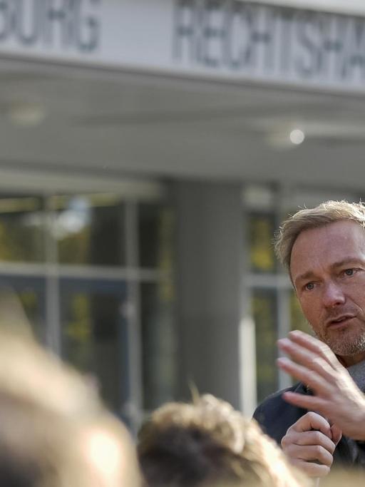 Christian Lindner steht vor einer Menschenmenge und redet, hinter ihm die Universität Hamburg.