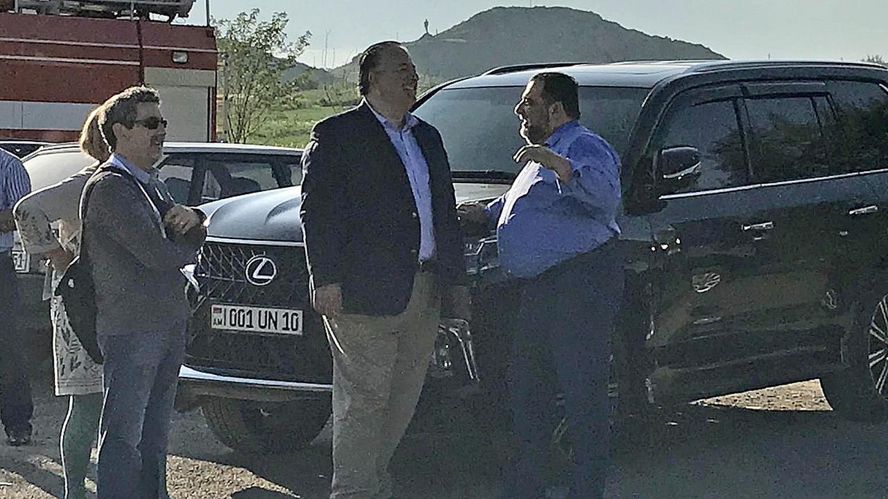 Männer stehend vor Jeep, im Hintergrund Berge Männer stehend vor Jeep, im Hintergrund Berge