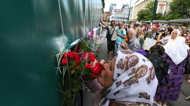 Eine alte Frau küsst Blumen an einem Konvoi in Sarajevo, mit dem die 175 neu identifizierten Leichen des Srebrenica-Massakers von 1995 transportiert werden.