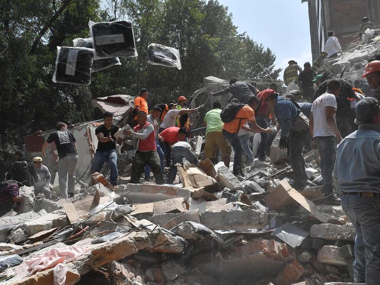 Einsatzkräfte und Bewohner suchen in Mexiko-Stadt unter Trümmern nach Verschütteten.