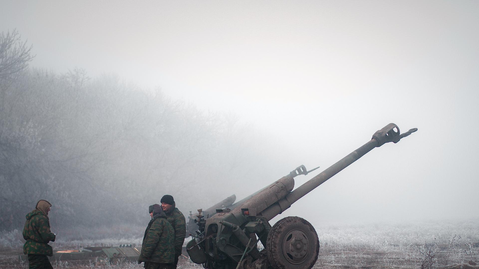 Separatisten im Osten der Ukraine stehen neben einer Artillerie-Kanone. Separatisten im Osten der Ukraine stehen neben einer Artillerie-Kanone.
