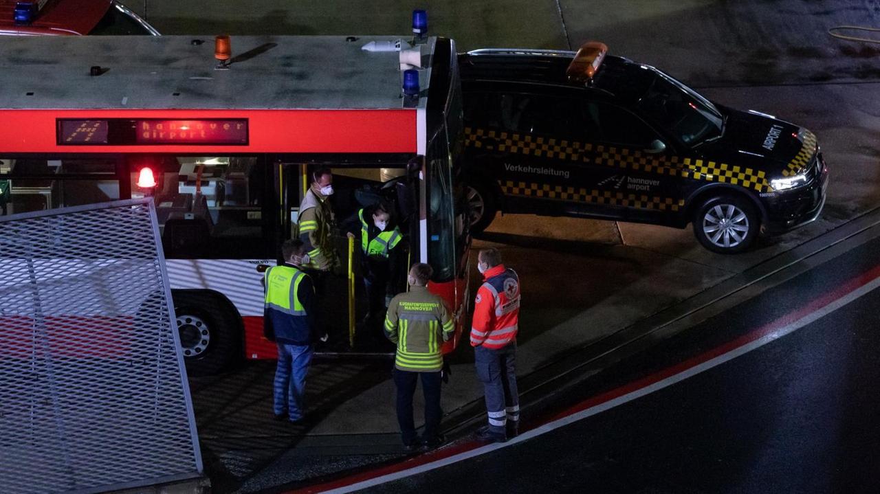 Einsatzkräfte stehen an und in einem Bus der Flughafenfeuerwehr auf dem Gelände des Flughafens Hannover-Langenhagen. Einsatzkräfte stehen an und in einem Bus der Flughafenfeuerwehr auf dem Gelände des Flughafens Hannover-Langenhagen.