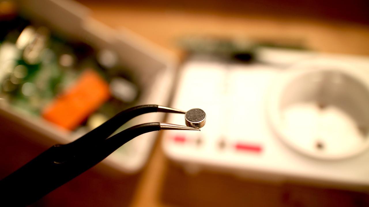 Ein Chip gehalten durch eine Zange Ein Chip gehalten durch eine Zange