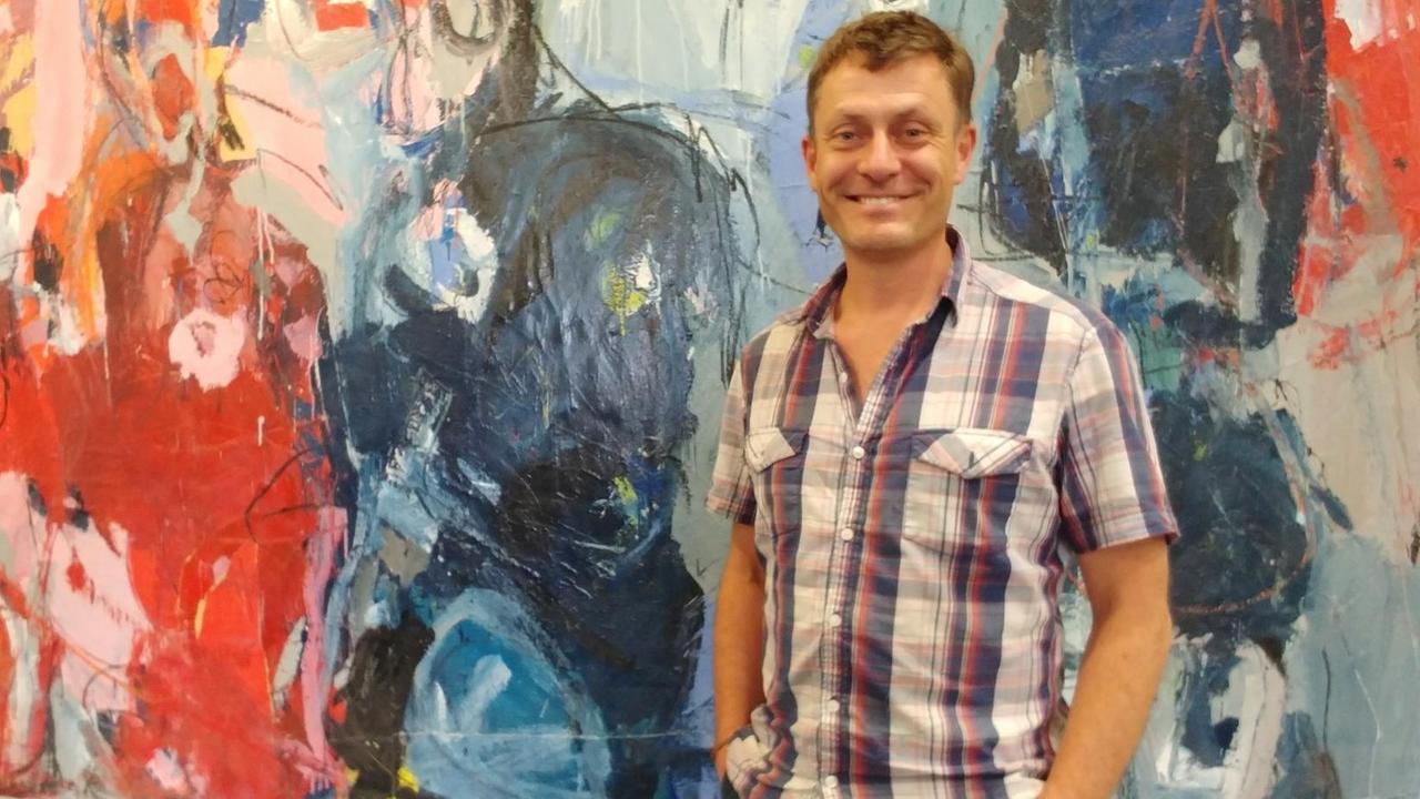 Steve Hudson, Sprecher der Corso-Serie "Brexit Monday" , steht vor einem bunten Gemälde im DLF-Funkhaus