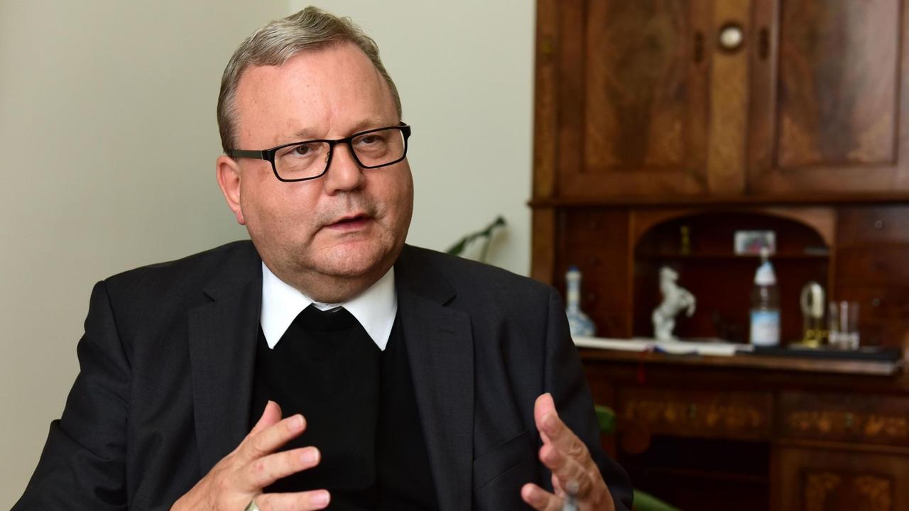 Der Osnabrücker Bischof Franz-Josef Bode sitzt am 19.08.2016 in Osnabrück (Niedersachsen) während eines Interviews unter einem Kreuz. Der Osnabrücker Bischof Franz-Josef Bode sitzt am 19.08.2016 in Osnabrück (Niedersachsen) während eines Interviews unter einem Kreuz.