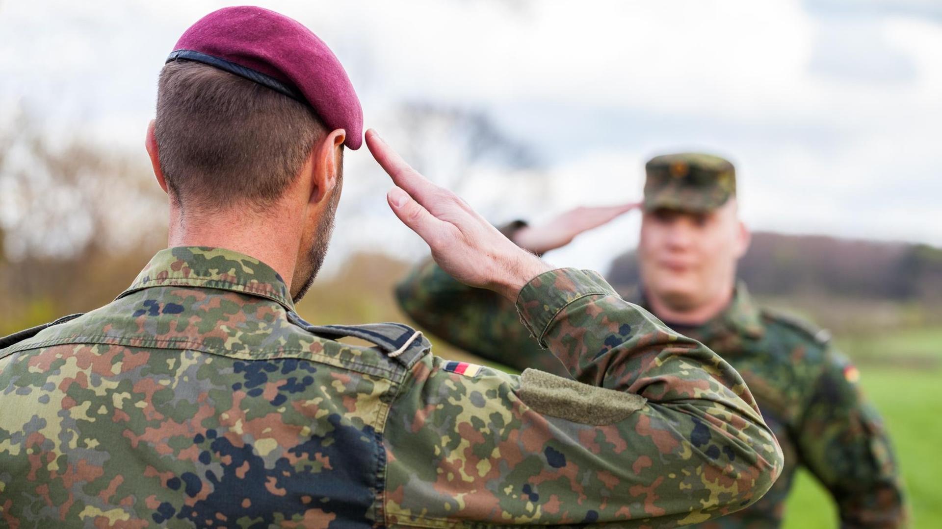 Zwei deutsche Soldaten der Bundeswehr salutieren einander. Zwei deutsche Soldaten der Bundeswehr salutieren einander.