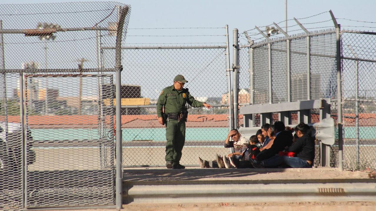 Eine Grenzbeamter spricht zu einer Gruppe von Migranten, die in den USA Asyl beantragen will; Grenze Mexiko-USA an der Grenze El Paso/Ciudad Juarez
