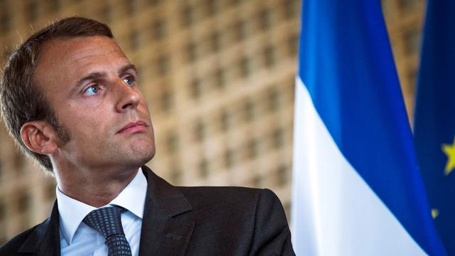 Frankreichs Wirtschaftminister Emmanuel Macron, im Hintergrund eine Fahne