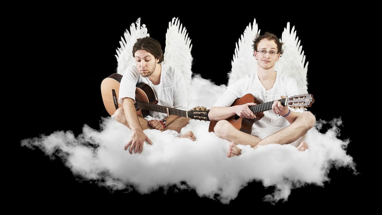 Das Duo als Engel verkleidet auf einer bauschigen, weißen Wolke sitzend Das Duo als Engel verkleidet auf einer bauschigen, weißen Wolke sitzend