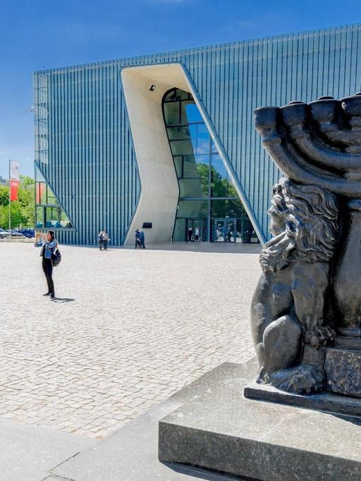 Im Vodergrund eine Statue, dahinter das Museum aus Glas.