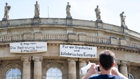 Transparente mit der Aufschrift "8. Mai 1945 Die Befreiung feiern 8. Mai 2020" und "Für ein friedliches und solidarisches Europa" hängen am Balkon des Opernhauses der Staatstheater Stuttgart.