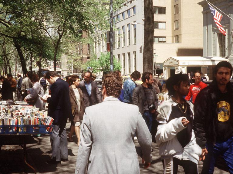 Straßenszene in der Fifth Avenue in Manhattan mit einem Bücherstand und flanierenden Passanten (Foto von 1987)