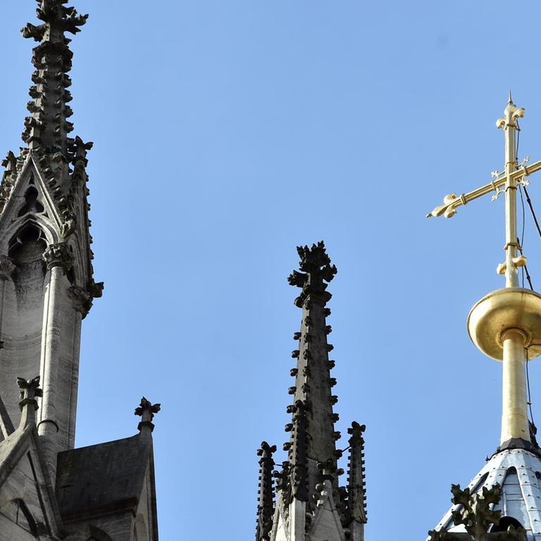 Ein goldenes Kreuz auf dem Kölner Dom leuchtet am 12.10.2017 in Köln (Nordrhein-Westfalen) in der Sonne. 