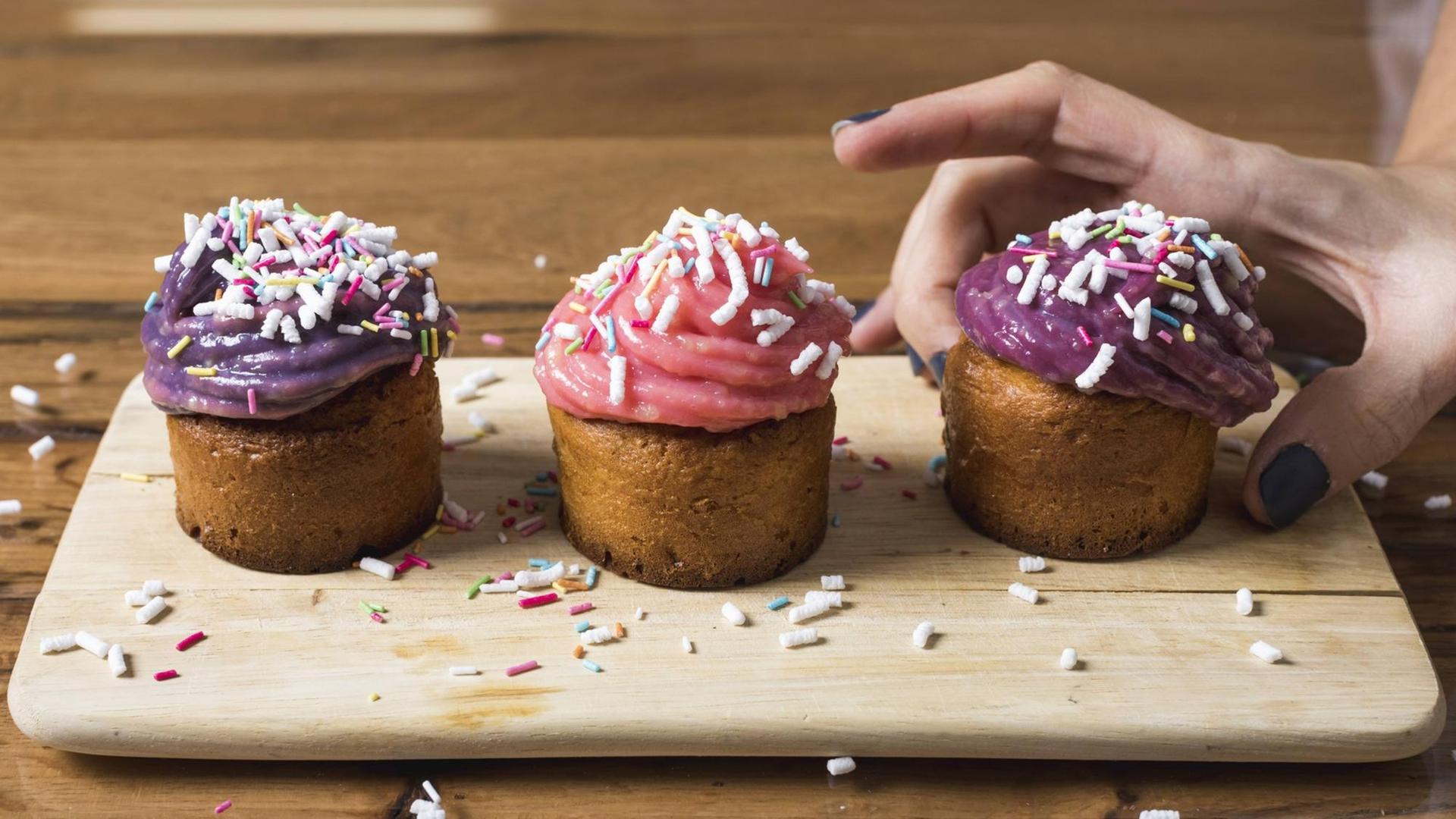 Eine Frau nimmt sich einen Muffin. Eine Frau nimmt sich einen Muffin.