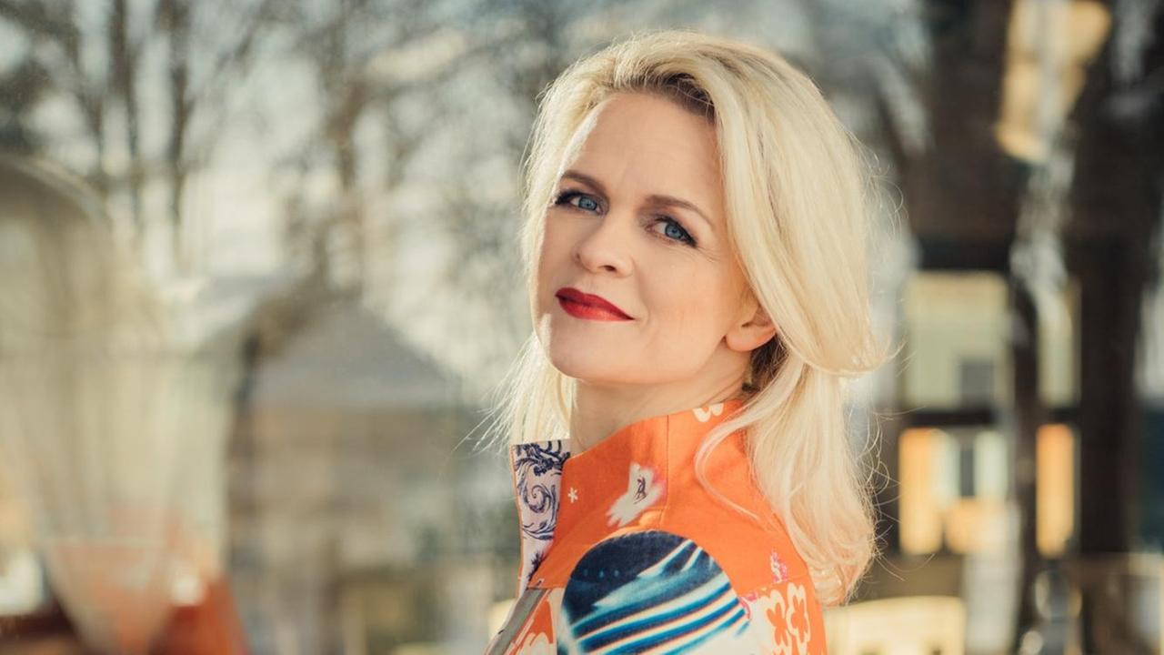 Die lettische Organistin Iveta Apkalna ist im Halbprofil zu sehen, sie hat blonde lange Haare und trägt ein orange-blaues langärmeliges Kleid. Die lettische Organistin Iveta Apkalna ist im Halbprofil zu sehen, sie hat blonde lange Haare und trägt ein orange-blaues langärmeliges Kleid.