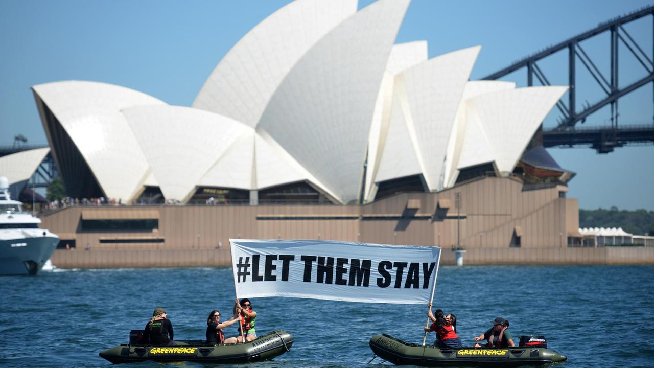 Mitglieder von Greenpeace halten ein Schild mit der Aufschrift "Let them stay" ("Lasst sie bleiben") vor dem Opernhaus in Sydney in die Höhe Mitglieder von Greenpeace halten ein Schild mit der Aufschrift "Let them stay" ("Lasst sie bleiben") vor dem Opernhaus in Sydney in die Höhe