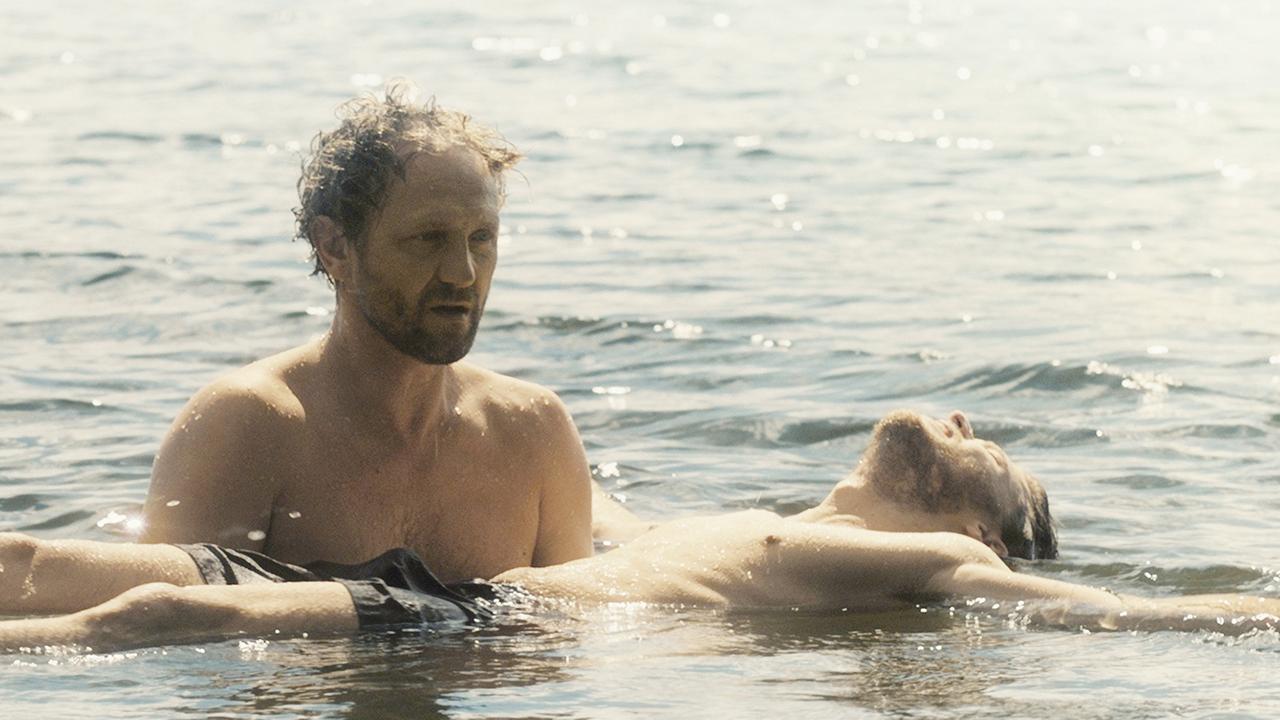 Filmszene aus "Im Namen des..." von Małgorzata Szumowska. Andrzej Chyra als Pater Adam (l) hält Mateusz Kosciukiewicz als Lukasz im Wasser in seinen Armen.