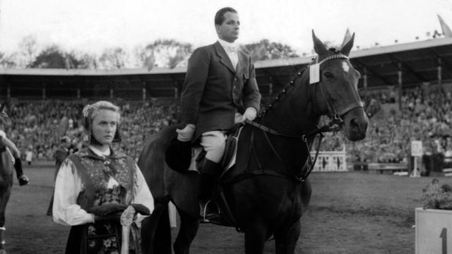 Hans Günter Winkler auf "Halla" während der Siegerehrung im Springreiten bei den Olympischen Reiterspielen 1956 in Stockholm.