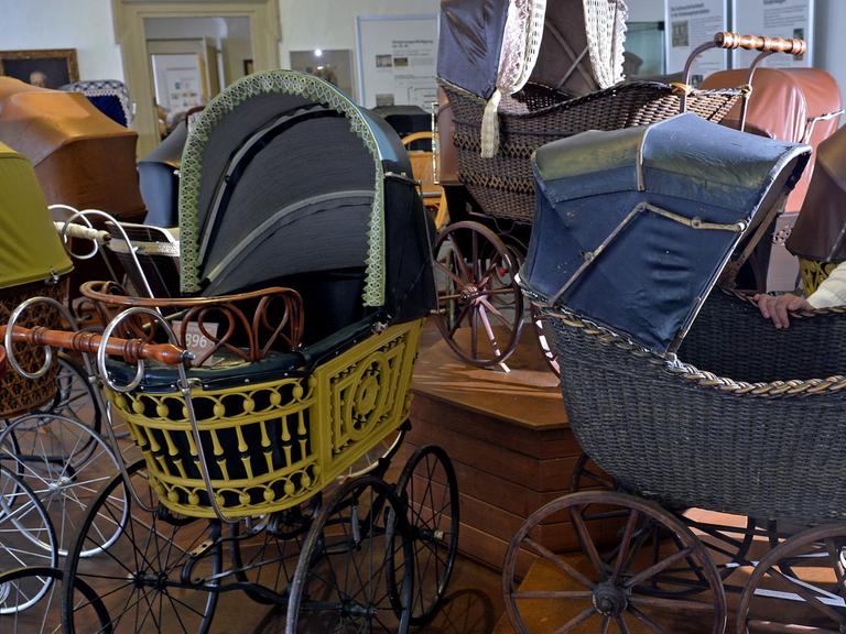 Die Leiterin des "Deutschen Kinderwagen Museums", Kristin Otto, steht im Schloss in Zeitz (Sachsen-Anhalt) neben einer Gruppe Zeitzer Kinderwagen aus der Zeit um 1900.
