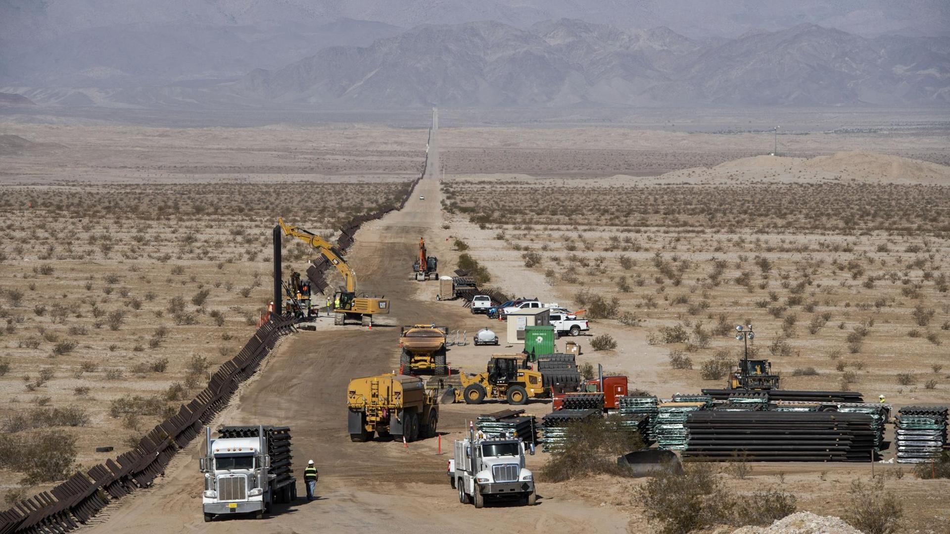 Baufahrzeuge reissen den alten Grenzzaun entlang der US-amerikanischen Grenze zu Mexiko ab, am Straßenrand liegt das Baumaterial für die neue Grenzmauer. Baufahrzeuge reissen den alten Grenzzaun entlang der US-amerikanischen Grenze zu Mexiko ab, am Straßenrand liegt das Baumaterial für die neue Grenzmauer.