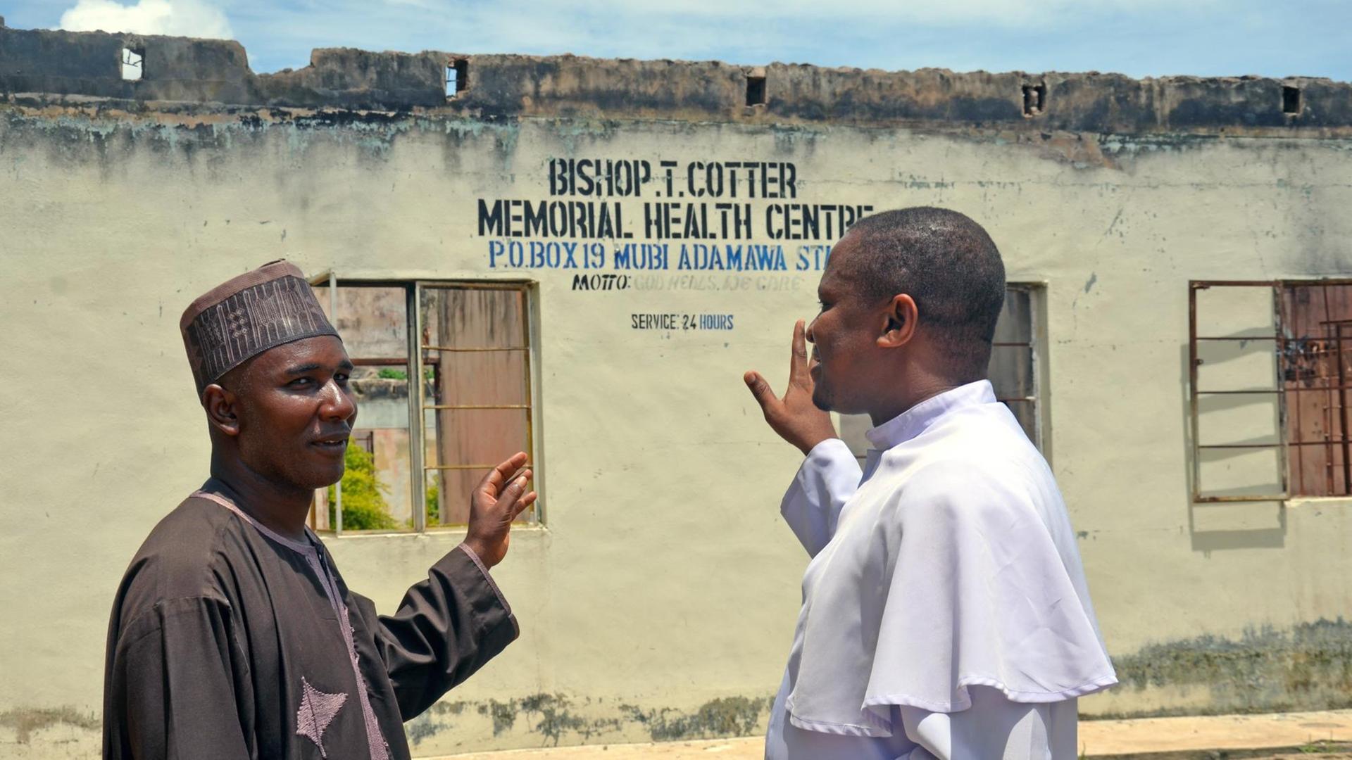 Yusuf Yaro (links), Vorsitzender des muslimischen Rates und Priester Alexander Miskita William (rechts) setzen sich für ein friedliches Zusammenleben in ihrer Heimatstadt Mubi ein. Yusuf Yaro (links), Vorsitzender des muslimischen Rates und Priester Alexander Miskita William (rechts) setzen sich für ein friedliches Zusammenleben in ihrer Heimatstadt Mubi ein.