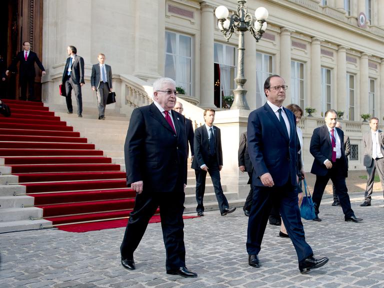 Frankreichs Präsident Francois Hollande (r.) und sein irakischer Amtskollege Fuad Masum passieren am 15. September 2014 den Weg vor dem französischen Außenministerium in Paris nach der Eröffnung einer internationalen Konferenz zur Lage im Irak.