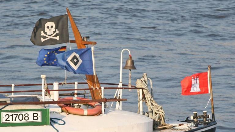 Fahnen vom HSV und vom FC St. Pauli wehen an einem Schiff im Wind Fahnen vom HSV und vom FC St. Pauli wehen an einem Schiff im Wind