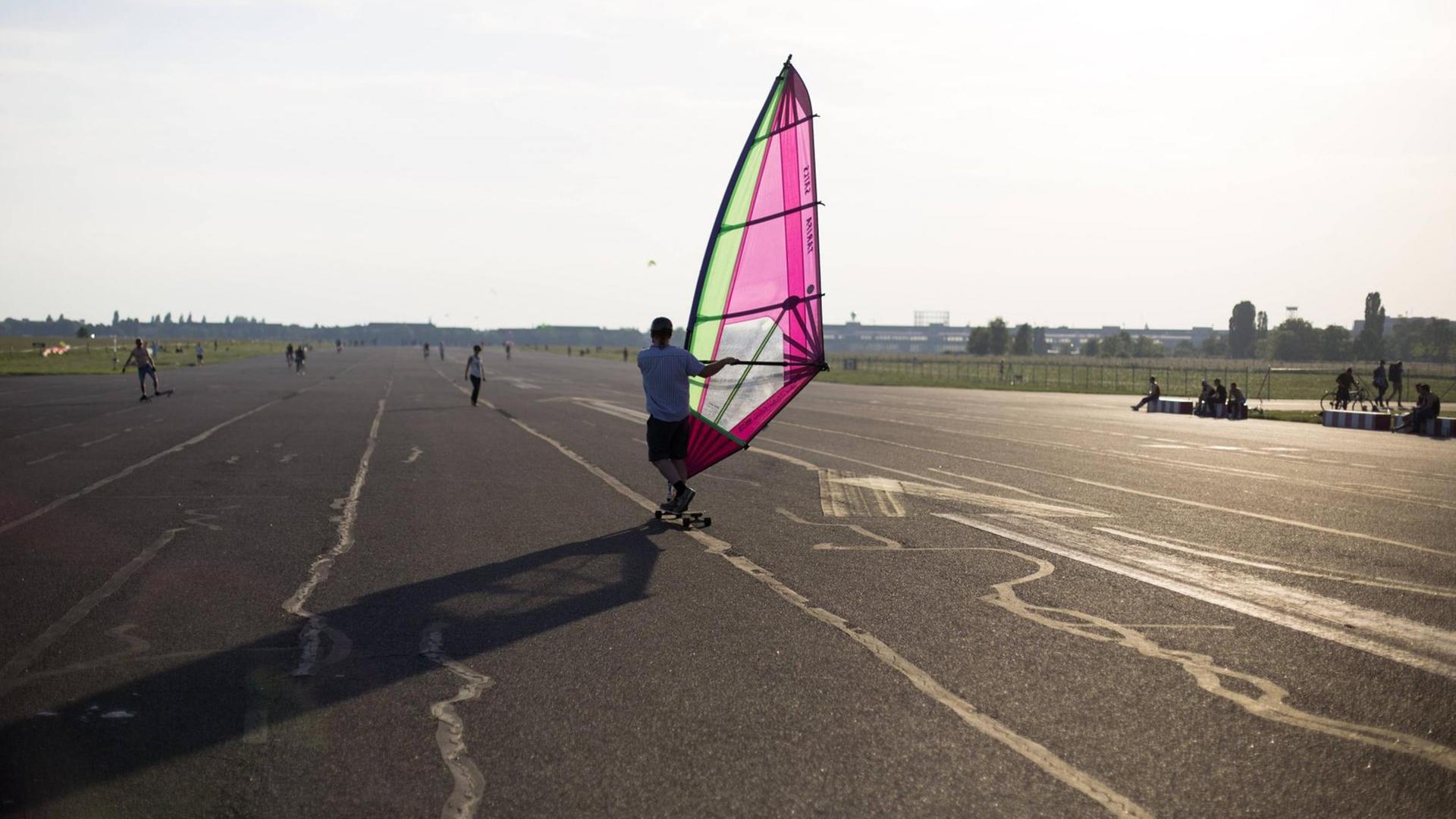 Ein Besucher fährt auf dem als Tempelhofer Freiheit bezeichneten ehemaligen Flughafen Tempelhof in Berlin mit einem Windsegel Longboard. A Visitor rides a lomgboard using a sail of windsurf at the urban park on the airfield of the former airport in Berlin Tempelhof known as Tempelhofer Feld. Tempelhofer Feld a Visitors runs on the as Temple Hofer Freedom former Airport Tempelhof in Berlin with a Wind sails Long Board a Visitor Rides a Using a Sail of Wind Surf AT The Urban Park ON The AIRFIELD of The Former Airport in Berlin Tempelhof known As Temple Hofer Field Temple Hofer Field Ein Besucher fährt auf dem als Tempelhofer Freiheit bezeichneten ehemaligen Flughafen Tempelhof in Berlin mit einem Windsegel Longboard. A Visitor rides a lomgboard using a sail of windsurf at the urban park on the airfield of the former airport in Berlin Tempelhof known as Tempelhofer Feld. Tempelhofer Feld a Visitors runs on the as Temple Hofer Freedom former Airport Tempelhof in Berlin with a Wind sails Long Board a Visitor Rides a Using a Sail of Wind Surf AT The Urban Park ON The AIRFIELD of The Former Airport in Berlin Tempelhof known As Temple Hofer Field Temple Hofer Field