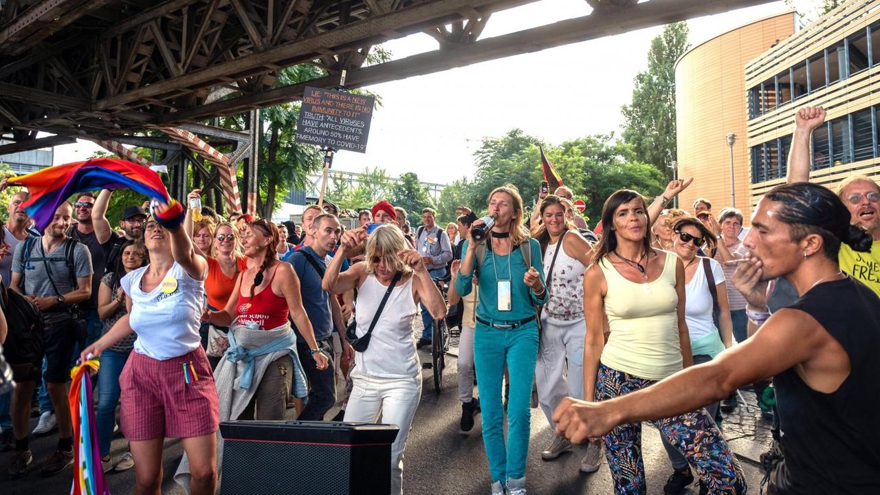 Mehrere Menschen stehen vor einer Musikbox und tanzen ausgelassen. Mehrere Menschen stehen vor einer Musikbox und tanzen ausgelassen.