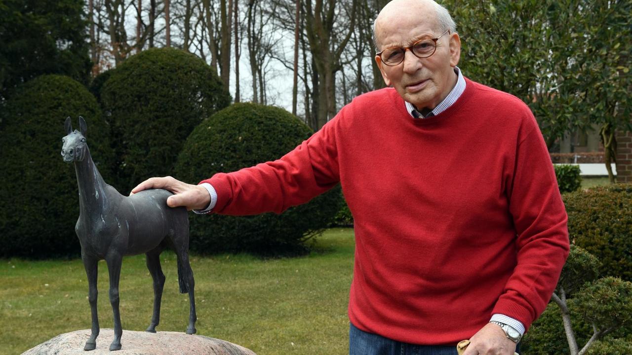 Der ehemalige Springreiter Hans Günter Winkler posiert neben der Bronzestatue seiner «Wunderstute» Halla, die auf einem Findling steht.