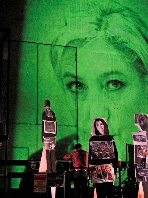Eine Szene aus dem Stück "Fear" von Falk Richter, aufgeführt an der Berliner Schaubühne – im Hintergrund ist in einer Videoprojektion Marine Le Pen, Parteivorsitzende der französischen Front National, zu sehen.