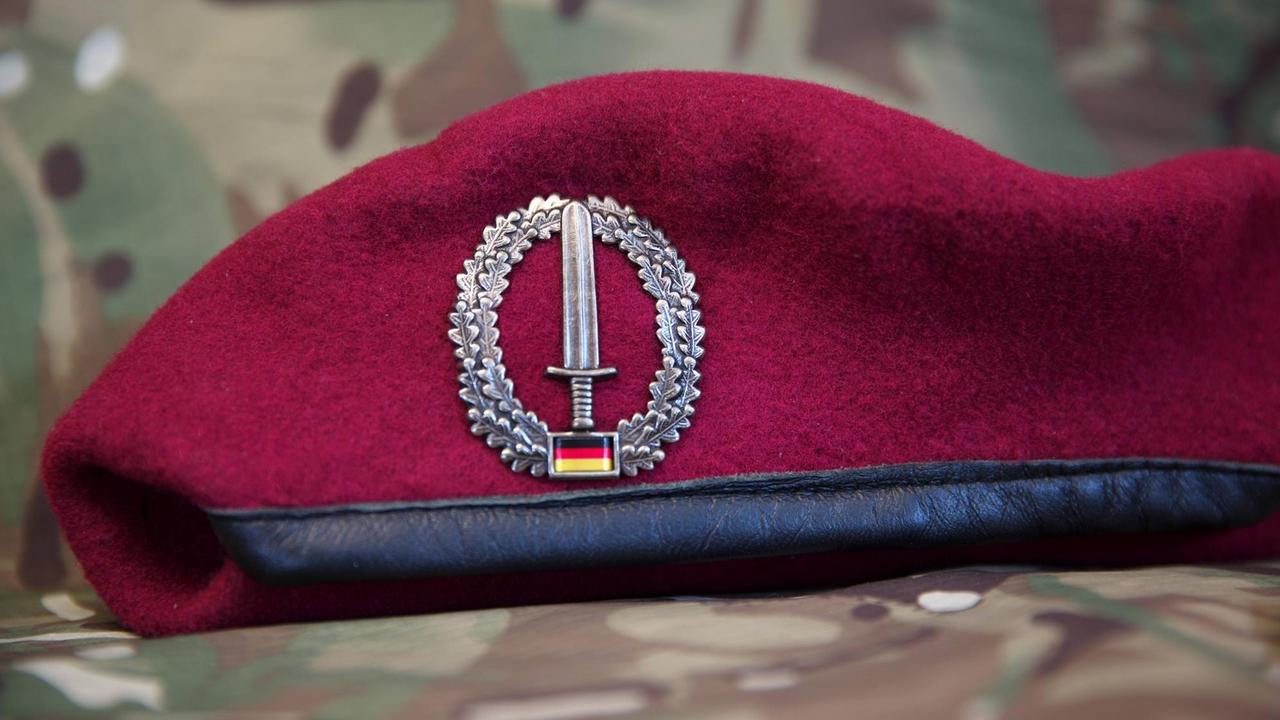 Die Kopfbedeckung des Kommando Spezialkräfte KSK ist das bordeauxrote Barett mit dem Barettabzeichen des KSK. Das Abzeichen zeigt das Kommandoschwert mit Eichenlaubumrandung und die Flagge der Bundesrepublik Deutschland. 