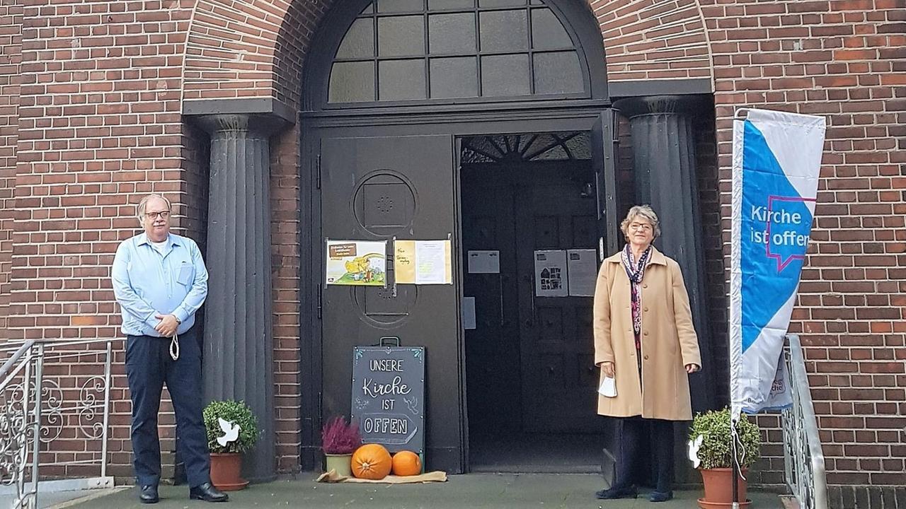 Michael Germ und Heide Apel vom Förderverein stehen vor dem Eingang der Herz-Jesu-Kirche
