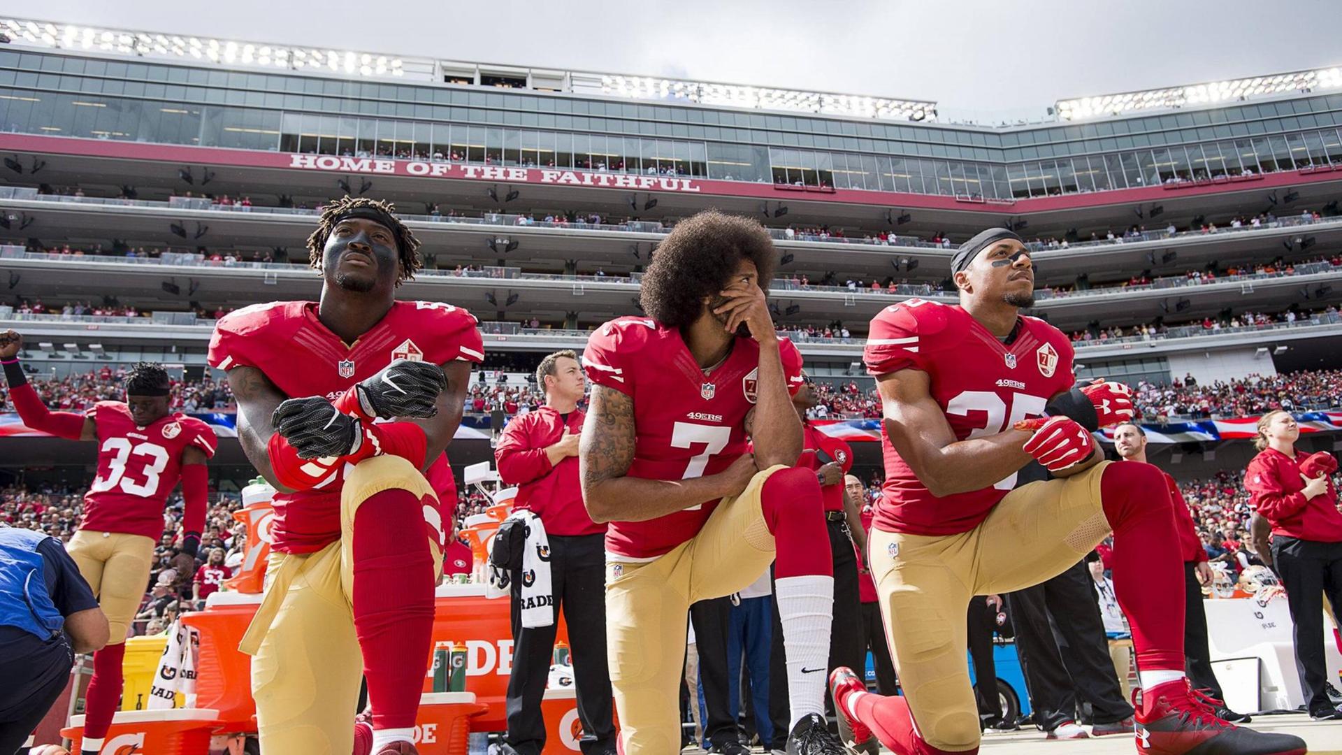 Colin Kaepernick (Mitte) kniet zusammen mit Eli Harold und Eric Reid vor einem Football-Spiel im Stadion am 2. Oktober 2016 in Santa Clara, Californien. Colin Kaepernick (Mitte) kniet zusammen mit Eli Harold und Eric Reid vor einem Football-Spiel im Stadion am 2. Oktober 2016 in Santa Clara, Californien.