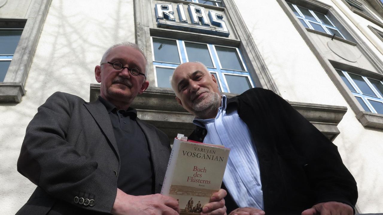 Varujan Vosganian (r.) und sein Übersetzer Ernest Wichner mit dem "Buch des Flüsterns" vor dem Funkhaus von Deutschlandradio Kultur, aus dem einst der RIAS sendete. Varujan Vosganian (r.) und sein Übersetzer Ernest Wichner mit dem "Buch des Flüsterns" vor dem Funkhaus von Deutschlandradio Kultur, aus dem einst der RIAS sendete.