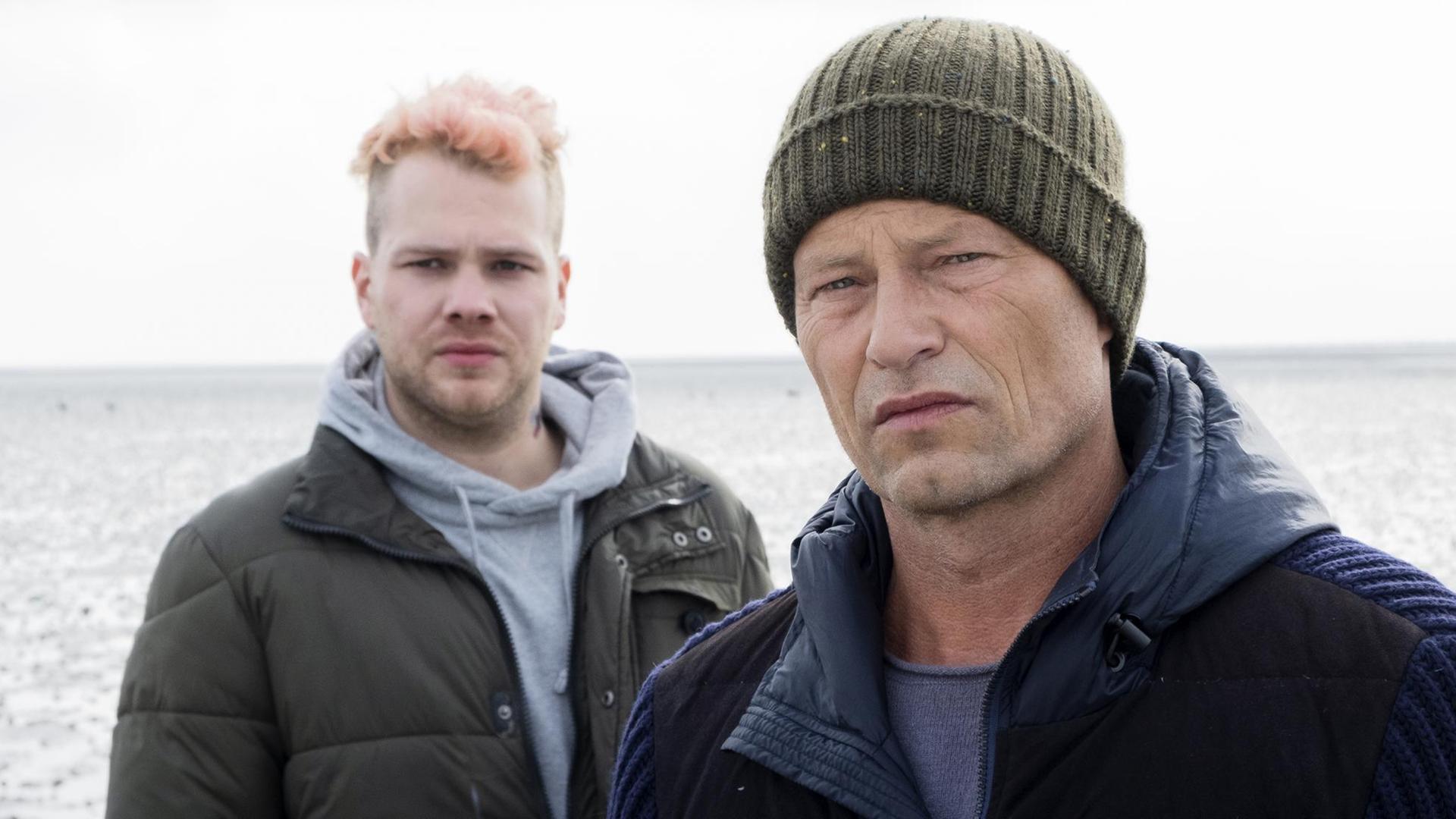 Szene aus dem Tatort "Tschill out": Tom Nix (Ben Münchow) und Nick (Til Schweiger) stehen nebeneinander. Szene aus dem Tatort "Tschill out": Tom Nix (Ben Münchow) und Nick (Til Schweiger) stehen nebeneinander.