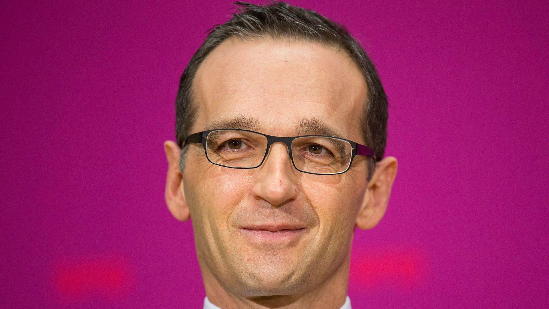 Vor pinkfarbenem Hintergrund schaut Justizminister Heiko Maas in die Kamera Vor pinkfarbenem Hintergrund schaut Justizminister Heiko Maas in die Kamera