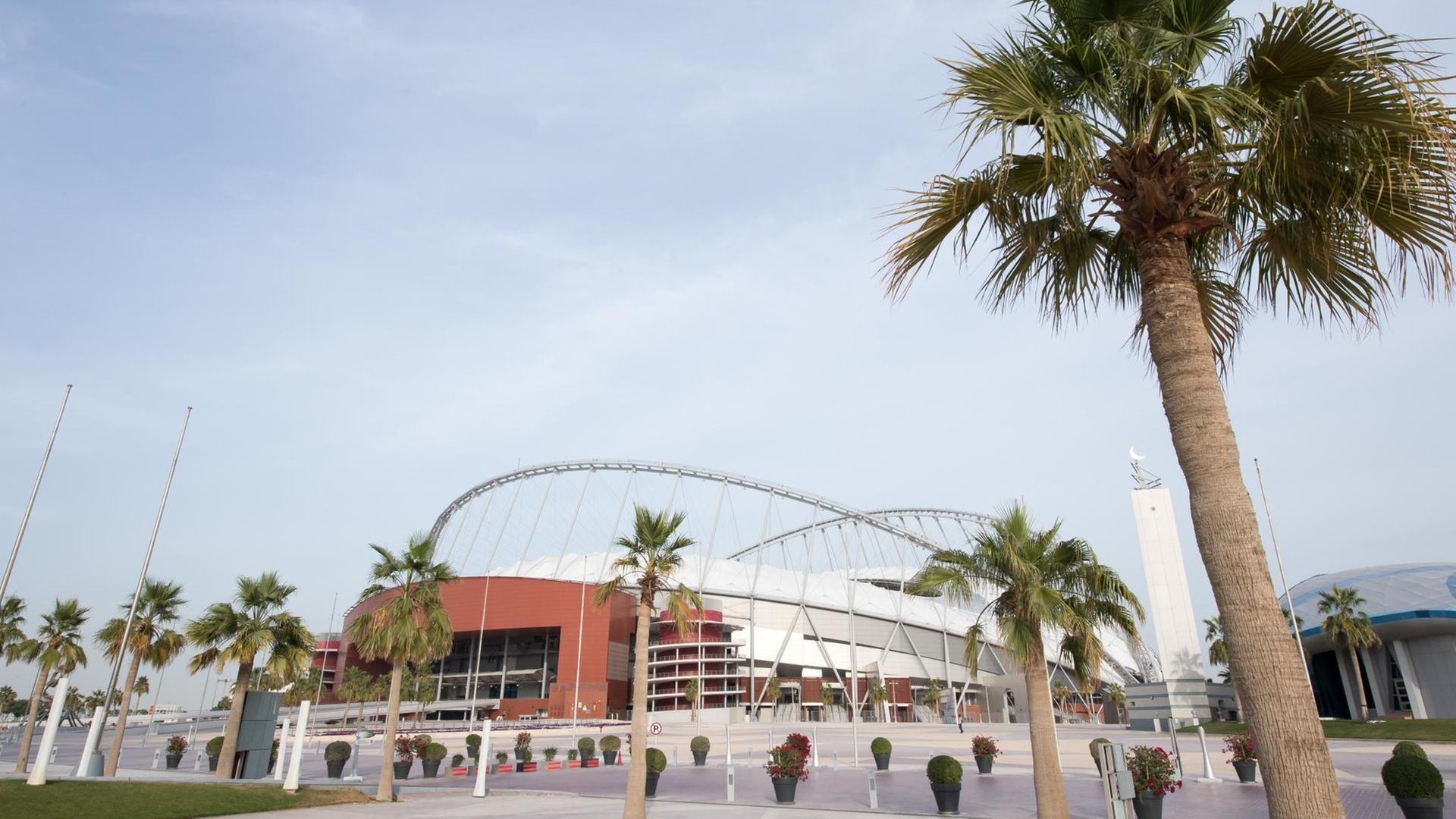 Das Khalifa International Stadion in der katarischen Wüstenstadt Doha, im Vordergrund eine Palme.