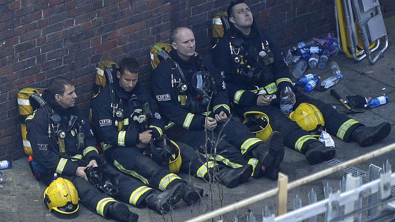 Das Bild zeigt erschöpfte Feuerwehrleute nach einem Einsatz in London. Das Bild zeigt erschöpfte Feuerwehrleute nach einem Einsatz in London.