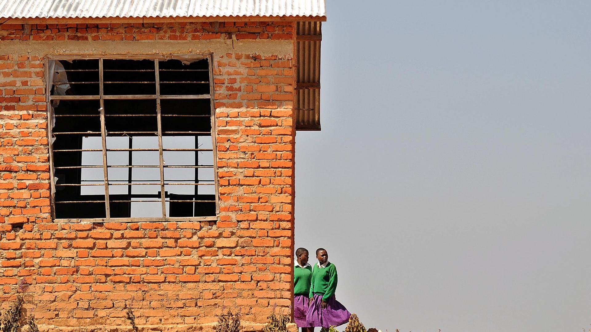 Zwei Schulmädchen während einer Pause vor dem Schulgebäude in Kilolo, Tansania
