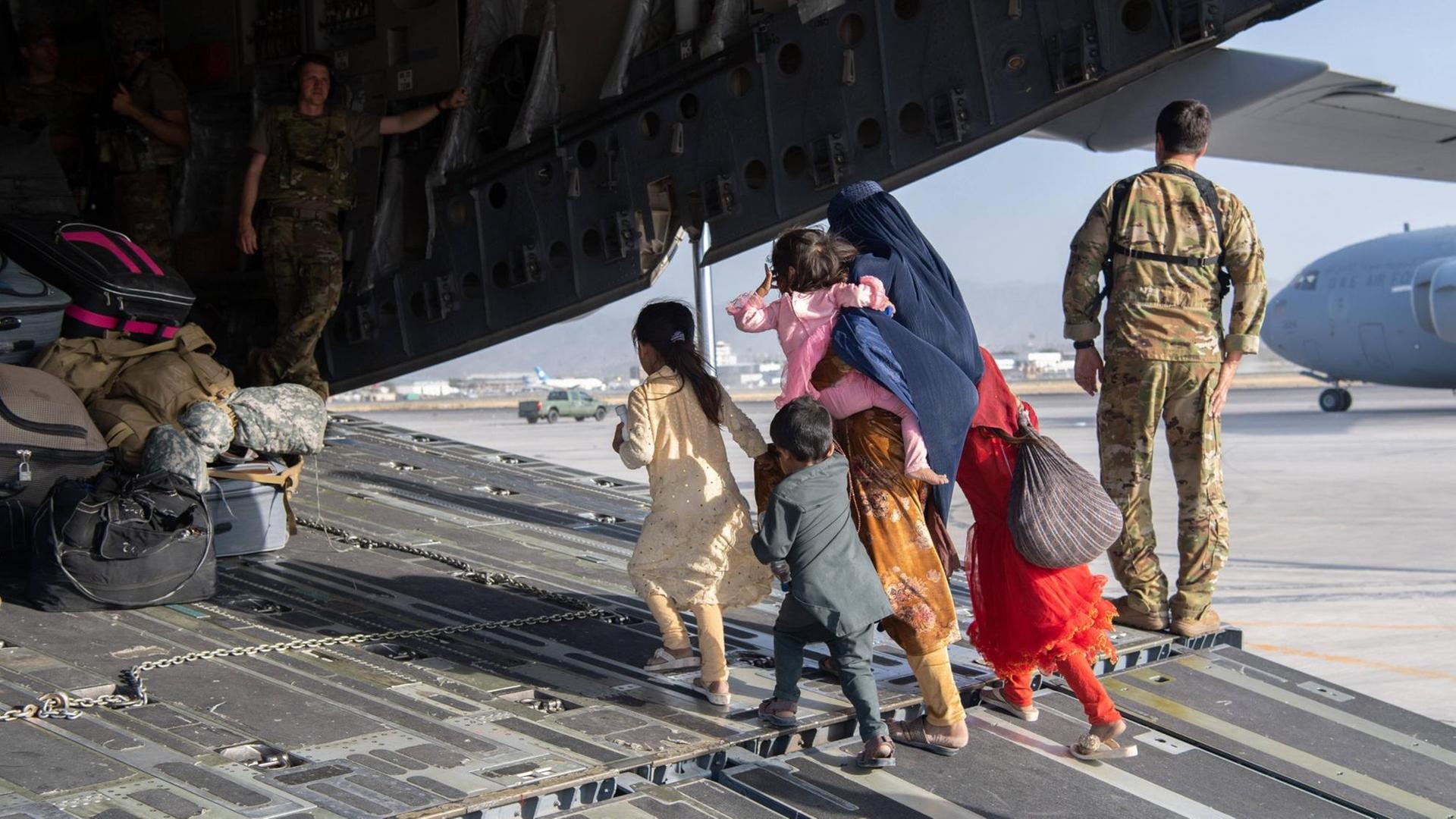 Eine afghanische Familie, Mutter mit ihren Kindern, ist auf dem Weg in ein Frachtflugzeug des US-Militärs, um vom Flughafen in Kabul ausgeflogen zu werden. 20210824_szp_z03_065 Copyright: xSgt.xDonaldxR.xAllen/USAFx Eine afghanische Familie, Mutter mit ihren Kindern, ist auf dem Weg in ein Frachtflugzeug des US-Militärs, um vom Flughafen in Kabul ausgeflogen zu werden. 20210824_szp_z03_065 Copyright: xSgt.xDonaldxR.xAllen/USAFx