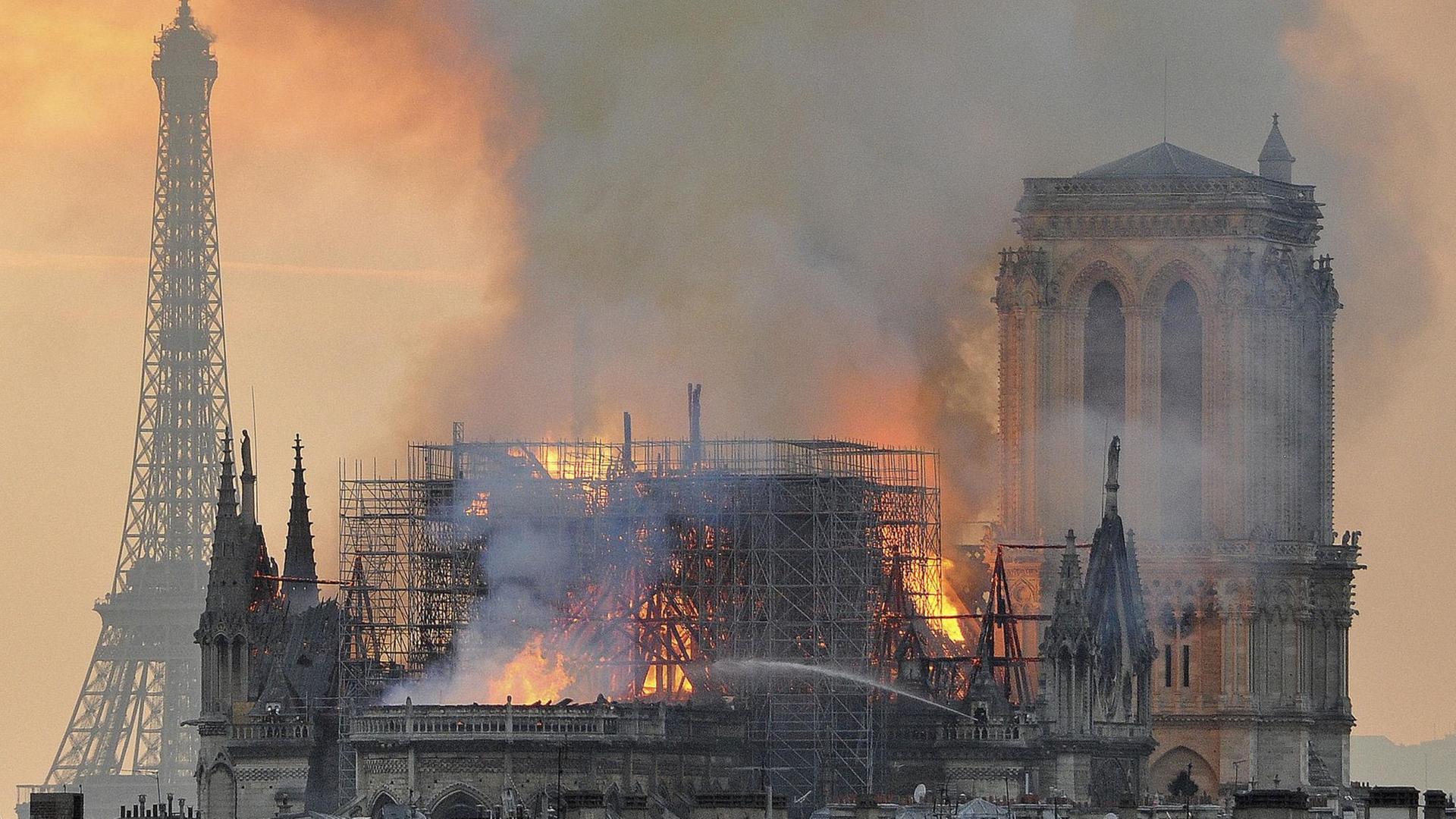 Die brennende Kirche Notre-Dame. Im Hintergrund ist der Eiffel-Turm. Die brennende Kirche Notre-Dame. Im Hintergrund ist der Eiffel-Turm.