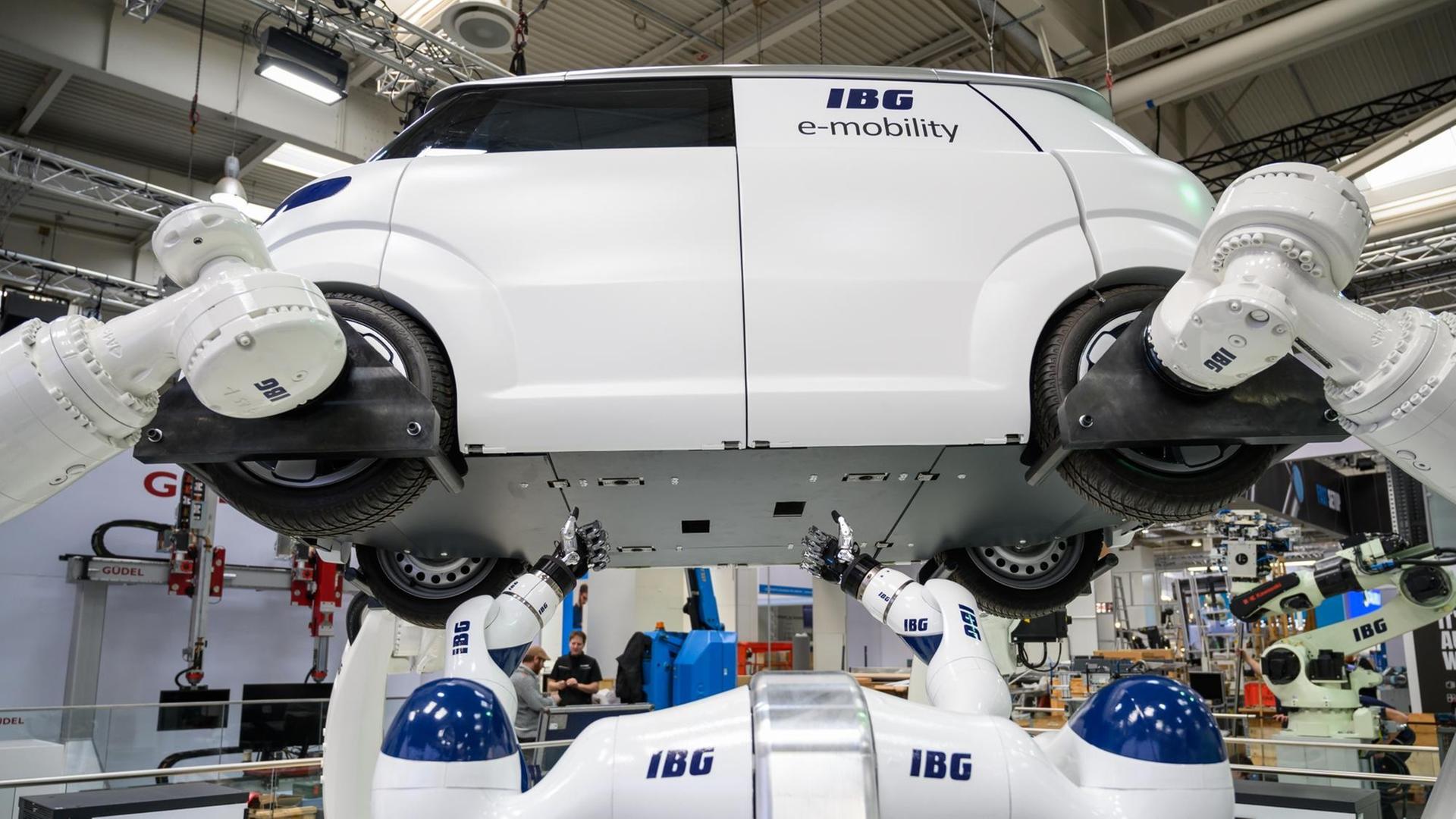 Das Foto zeigt den Stand des Herstellers IBG auf der Hannover Messe. Dort werden Roboter gezeigt, die an einem Automodell arbeiten. Das Foto zeigt den Stand des Herstellers IBG auf der Hannover Messe. Dort werden Roboter gezeigt, die an einem Automodell arbeiten.