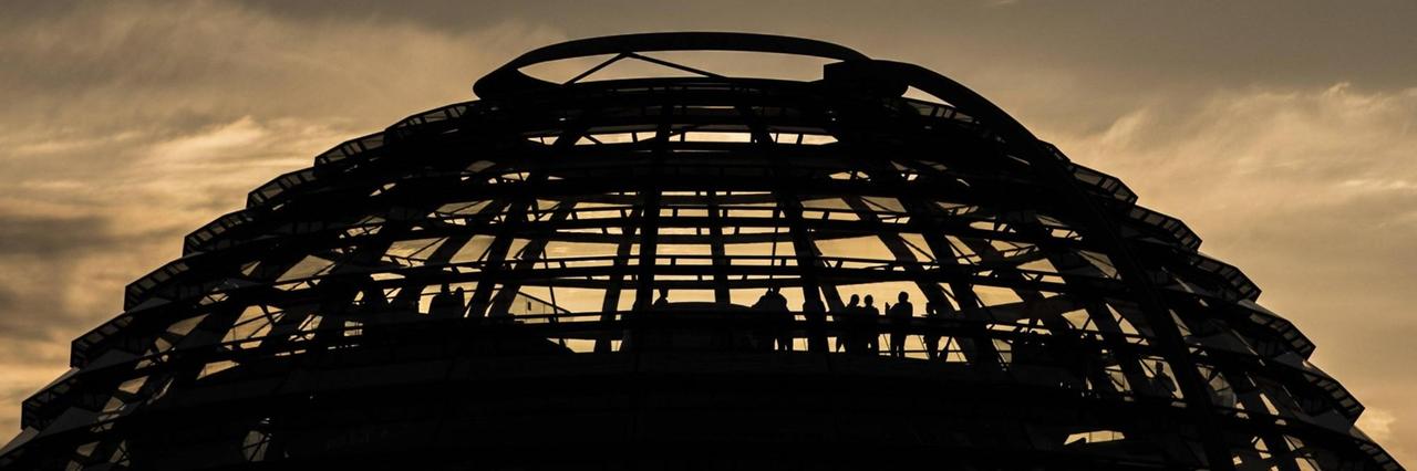 Besucher stehen in der Kuppel des Reichstags, aufgenommen während des Sonnenuntergangs. Besucher stehen in der Kuppel des Reichstags, aufgenommen während des Sonnenuntergangs.
