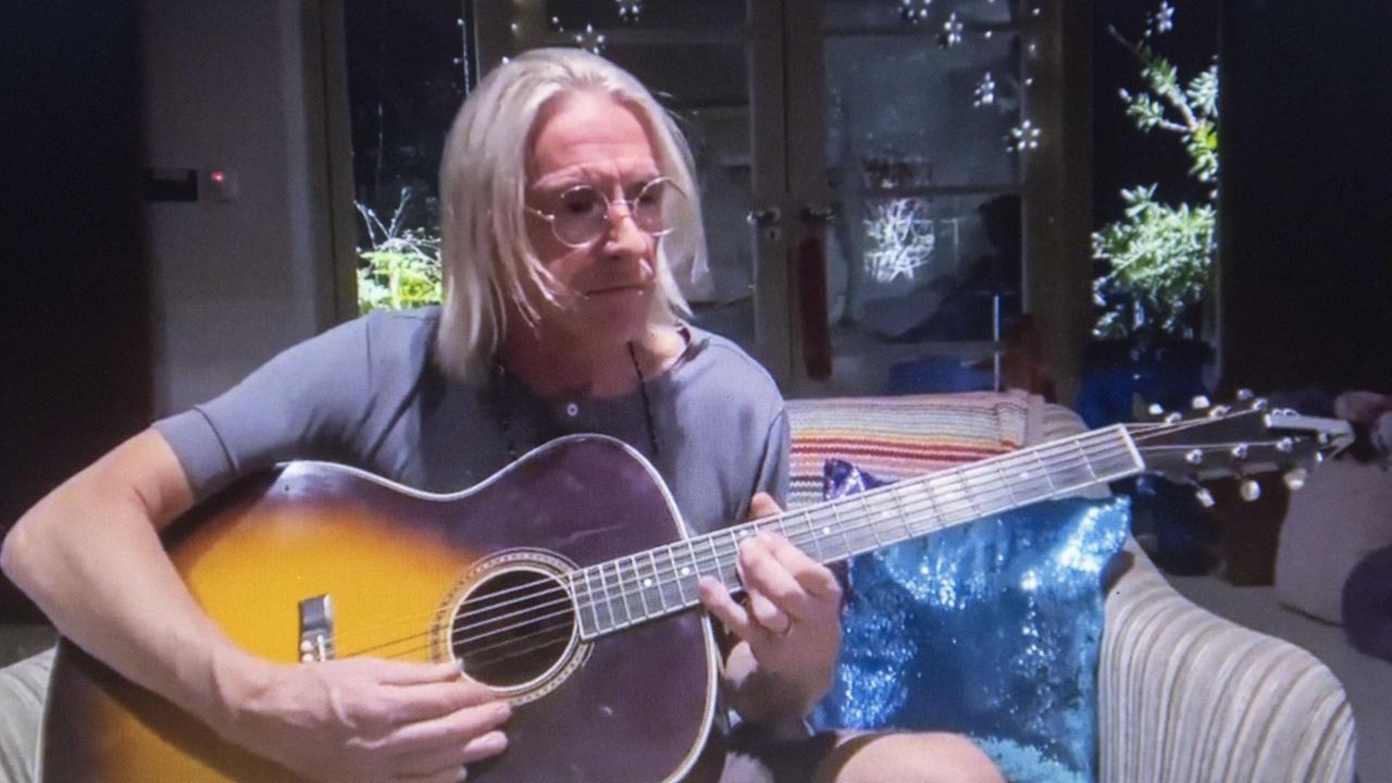 Paul Weller sitzt mit einer Gitarre auf einem Sofa. Im Hintergrund ist eine Terrassentür zu sehen. Paul Weller sitzt mit einer Gitarre auf einem Sofa. Im Hintergrund ist eine Terrassentür zu sehen.