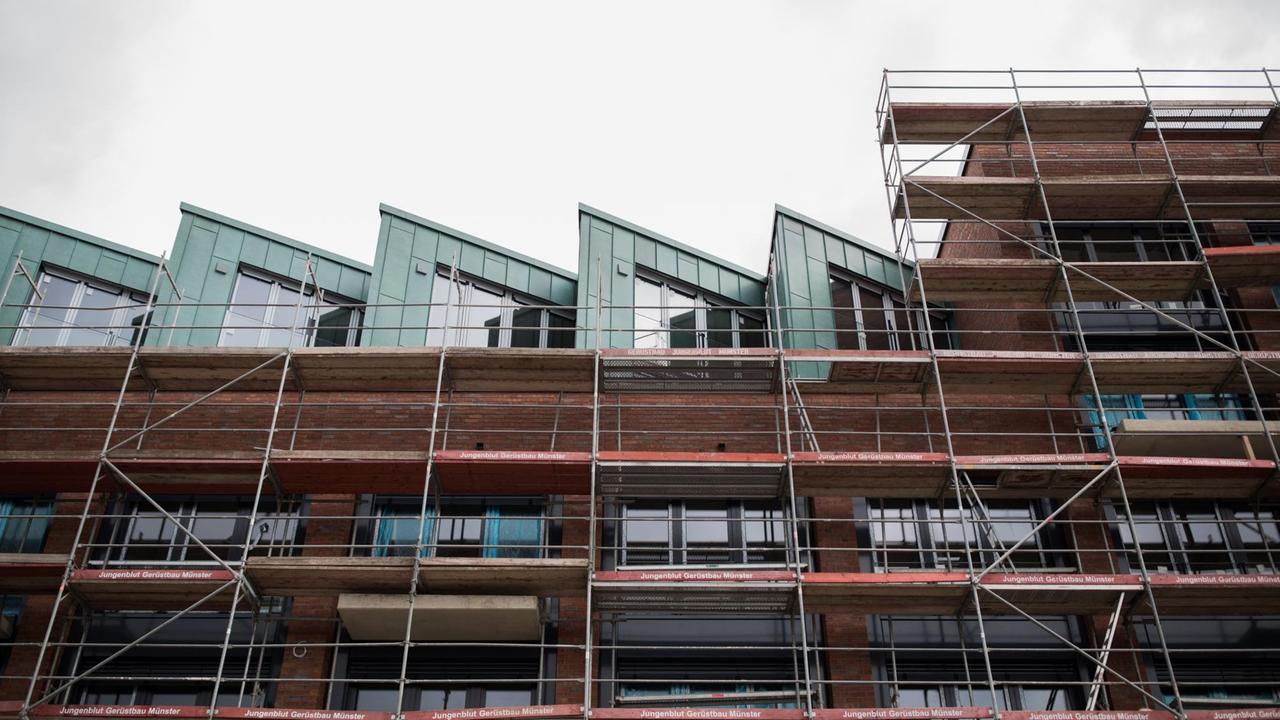 Blick aus der Untersicht auf einen Münsteraner Neubau, noch im Gerüst. Blick aus der Untersicht auf einen Münsteraner Neubau, noch im Gerüst.