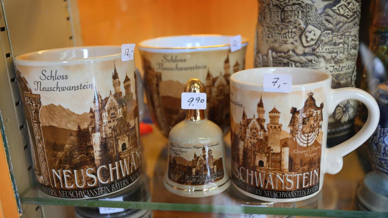 Braune Tassen mit dem Aufdruck des brühmten Schlosses und dem Namen Neuschwanstein Braune Tassen mit dem Aufdruck des brühmten Schlosses und dem Namen Neuschwanstein