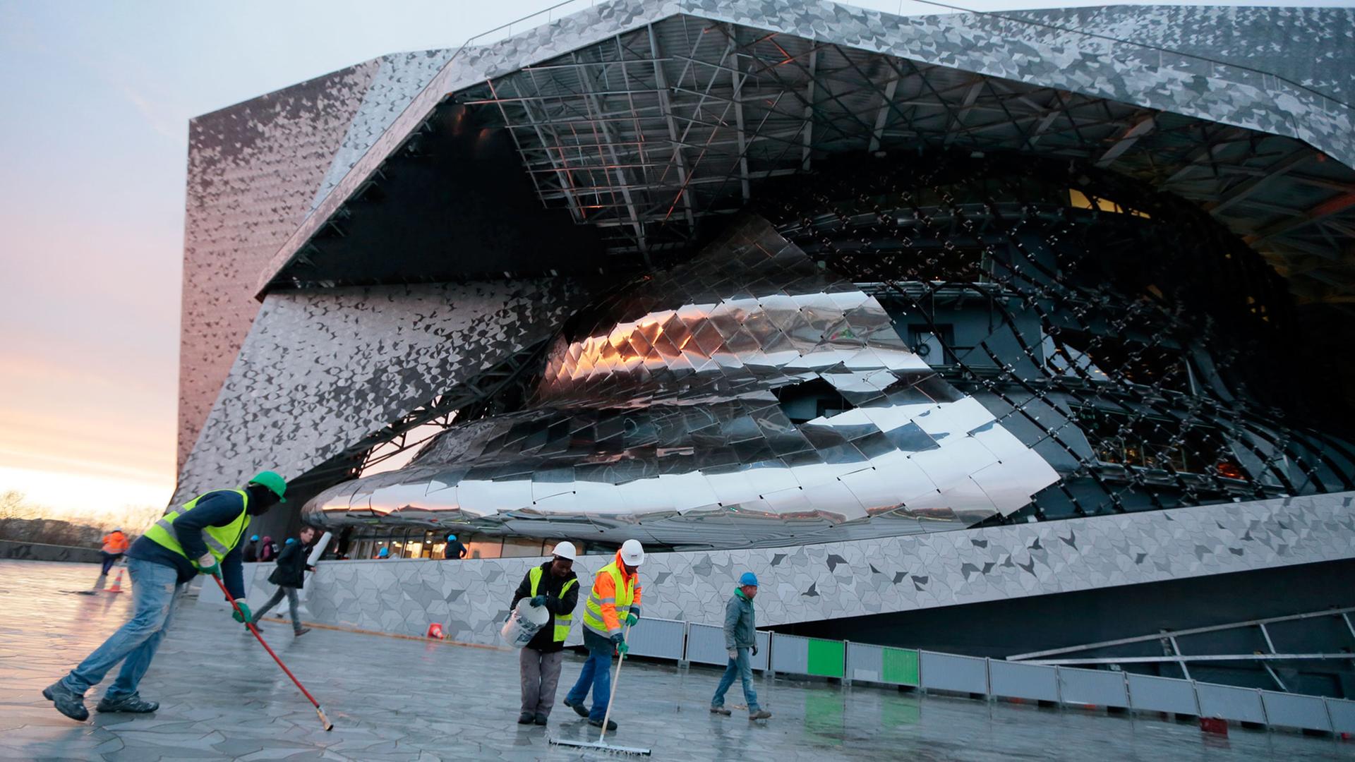 Arbeiter schrubben den Boden vor der neuen Philharmonie de Paris am 13. Januar 2015 kurz vor ihrer Eröffnung am 14. Januar 2015 im Nordosten der französischen Hauptstadt. Arbeiter schrubben den Boden vor der neuen Philharmonie de Paris am 13. Januar 2015 kurz vor ihrer Eröffnung am 14. Januar 2015 im Nordosten der französischen Hauptstadt.