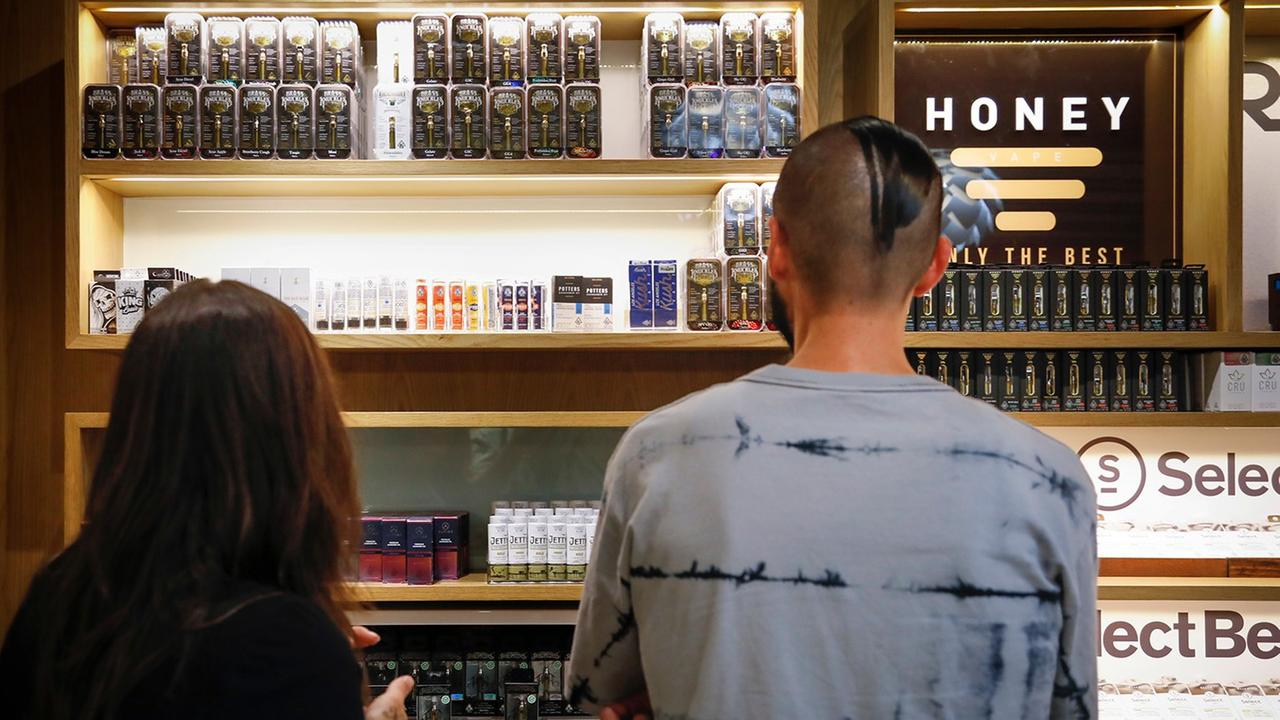 Junge Erwachsene stehen vor einer Auslage mit Vaping-Produkten in den USA. Junge Erwachsene stehen vor einer Auslage mit Vaping-Produkten in den USA.