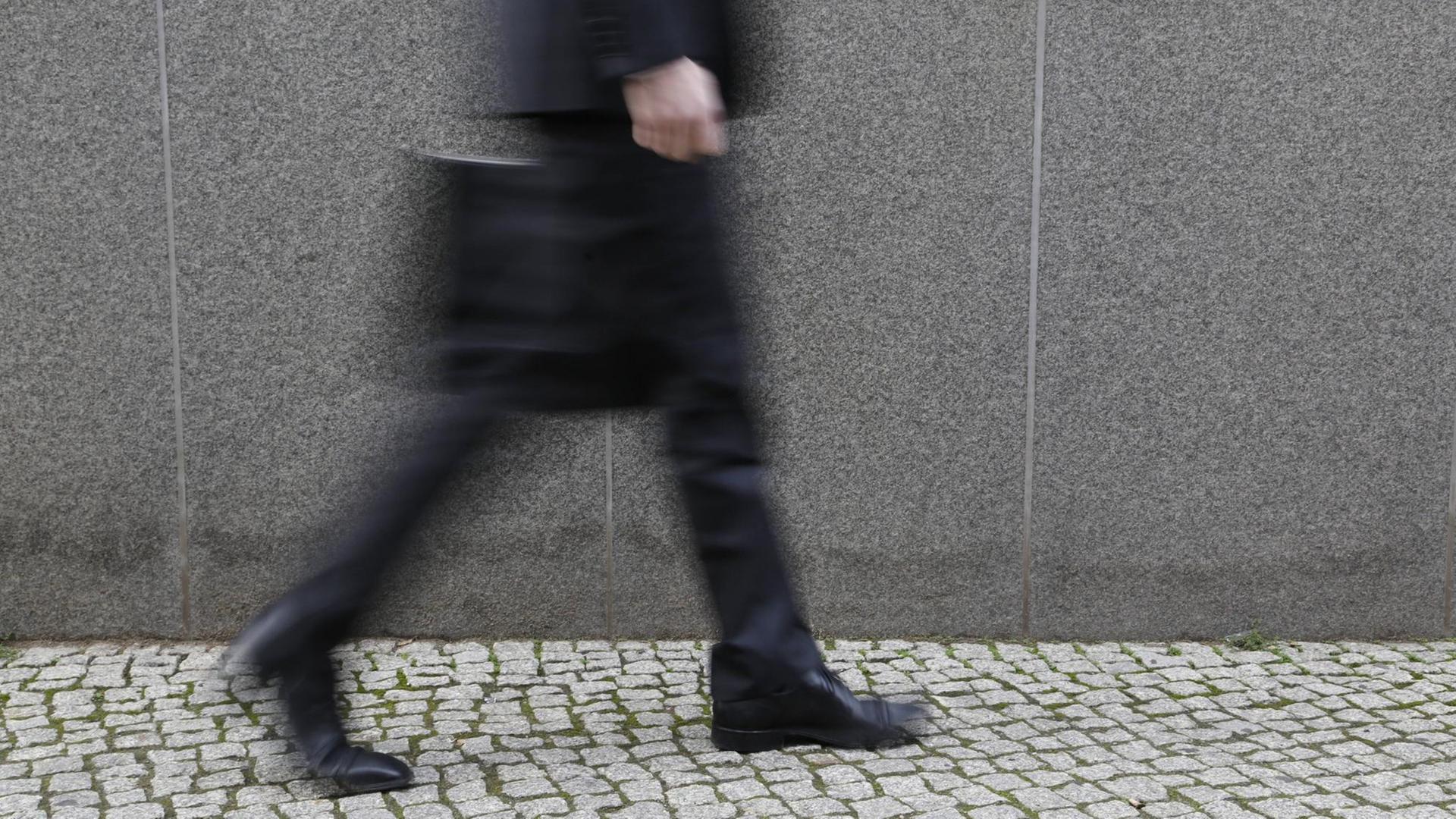 Geschäftsmann mit Aktenkoffer läuft auf der Straße Geschäftsmann mit Aktenkoffer läuft auf der Straße